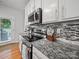 Modern kitchen with stainless steel appliances, granite countertops, and stylish tile backsplash, great for cooking at 1228 Rising Oak Dr, Charlotte, NC 28206