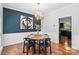 This bright dining room features hardwood floors, a unique light fixture, and decorative wall art at 13010 Indian Hills Ln, Charlotte, NC 28278