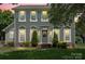 Charming two-story home with a well-manicured lawn, decorative shrubs, and a welcoming front entrance at 13010 Indian Hills Ln, Charlotte, NC 28278