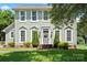 Charming two-story home with a well-manicured lawn, decorative shrubs, and a welcoming front entrance at 13010 Indian Hills Ln, Charlotte, NC 28278