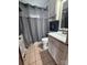 Compact bathroom with a white vanity, neutral tile, and shower with grey curtain at 1314 Hathcock Ave, Albemarle, NC 28001