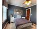 This is a quaint bedroom, with a light colored ceiling fan, a plaid bedspread, and gray painted walls at 1314 Hathcock Ave, Albemarle, NC 28001