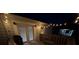 Well-lit wooden deck with French doors, string lights, grill and lounge chair, ideal for evening relaxation at 1314 Hathcock Ave, Albemarle, NC 28001