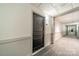 Hallway with gray carpet and paneling, featuring a unit door with an electronic lock at 1315 East Blvd # 327, Charlotte, NC 28203
