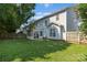 Spacious backyard with a screened-in porch, green grass, and wooden fence at 15280 Leslie Brook Rd, Huntersville, NC 28078