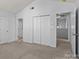 Bright bedroom with neutral walls, plush carpeting, and a spacious closet for ample storage at 15280 Leslie Brook Rd, Huntersville, NC 28078