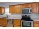 Close-up of kitchen features stainless steel appliances and wood cabinetry at 15280 Leslie Brook Rd, Huntersville, NC 28078
