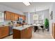 Bright kitchen features an island, stainless steel appliances, wood cabinetry, and dining area at 15280 Leslie Brook Rd, Huntersville, NC 28078