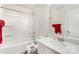 Bright bathroom featuring a shower-tub combo, tiled walls, and a single sink vanity with a framed mirror at 15636 Oleander Dr, Charlotte, NC 28278