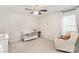 Neutral bedroom featuring a ceiling fan, plush carpet, a crib, and a cozy chair with toys near the window at 15636 Oleander Dr, Charlotte, NC 28278