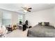 Bedroom with a gray bed, desk, and ceiling fan, providing a cozy and functional space at 15636 Oleander Dr, Charlotte, NC 28278