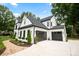 Stunning modern farmhouse with lush landscaping, black trim, and a two-car garage at 16112 Terry Ln, Huntersville, NC 28078