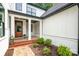 Inviting front porch with brick steps, garden beds, and an elegant wood front door at 16112 Terry Ln, Huntersville, NC 28078