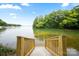 Steps leading to lake with scenic view and natural setting with a boat house at 16112 Terry Ln, Huntersville, NC 28078