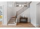 Elegant staircase with wood treads, black metal railings, and stylish console table at 16112 Terry Ln, Huntersville, NC 28078