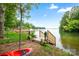 Beautiful waterfront view with private dock access and a kayak, surrounded by lush greenery, offering serene lakeside living at 16112 Terry Ln, Huntersville, NC 28078