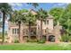 Picturesque backyard featuring lush greenery, stone accents, and mature palm trees, perfect for outdoor enjoyment at 174 Hickory Hill Rd, Mooresville, NC 28117