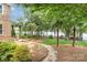 Stunning backyard view showcasing lush landscaping, mature trees, and tranquil pathway leading to the lake at 174 Hickory Hill Rd, Mooresville, NC 28117