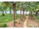 Backyard view with palm trees, grass area, and a peek of the lake at 174 Hickory Hill Rd, Mooresville, NC 28117