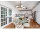 A breakfast nook with a glass table, decorative chairs, chandelier, and white cabinets at 174 Hickory Hill Rd, Mooresville, NC 28117