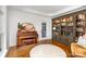 A living room with a piano, decorative mirror, hardwood floors, and a built-in bookcase at 174 Hickory Hill Rd, Mooresville, NC 28117