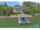 Lake home featuring a boat dock and boat with water views and well maintained landscaping at 18007 Harbor Light Blvd, Cornelius, NC 28031