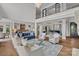 Open-concept living room with a fireplace, high ceilings, staircase, and hardwood floors at 18007 Harbor Light Blvd, Cornelius, NC 28031