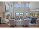A living room features an elegant fireplace, high ceilings, lake views, and neutral toned furniture at 18007 Harbor Light Blvd, Cornelius, NC 28031