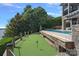 Backyard golf putting green with waterfront views near an in-ground pool and stone retaining wall at 18007 Harbor Light Blvd, Cornelius, NC 28031