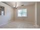 Neutral dining area featuring tiled floor, simple chandelier, and ample natural light at 1801 Teddington Dr, Charlotte, NC 28214