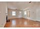 Well-lit living room with hardwood floors, fireplace, and access to other rooms at 1801 Teddington Dr, Charlotte, NC 28214