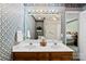 Bathroom with a double sink vanity, large mirror, and decorative wallpaper at 1958 Cameron Heights Cir, Denver, NC 28037