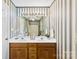 Bathroom featuring double sink vanity, large mirror, ceiling fan, and vertically-striped wallpaper at 1958 Cameron Heights Cir, Denver, NC 28037