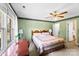 Cozy bedroom featuring a floral-patterned quilt, ceiling fan, and ample natural light from the large window at 1958 Cameron Heights Cir, Denver, NC 28037