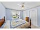 Bedroom with blue walls, ceiling fan, a window with sheer curtains, and double closet at 1958 Cameron Heights Cir, Denver, NC 28037