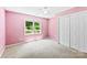 Bedroom with pink walls, carpet, a window looking out onto trees and a double closet at 1958 Cameron Heights Cir, Denver, NC 28037