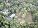 Aerial view of a house and outbuilding surrounded by a lush green forest at 209 Falcon Dr, Concord, NC 28025