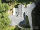 Aerial view of a gray roofed house with a long driveway and patio with outdoor furniture at 209 Falcon Dr, Concord, NC 28025