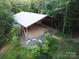 Aerial view of the expansive shed and firepit area and mature trees at 209 Falcon Dr, Concord, NC 28025