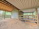 Barn interior with dirt floor, wooden beams, and secure fencing, great for livestock or storage at 209 Falcon Dr, Concord, NC 28025