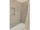 Modern bathroom featuring vertical grey tile, built-in shower niche, and a white bathtub at 209 Falcon Dr, Concord, NC 28025