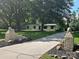 Inviting single-story home with a charming driveway entrance adorned with lion statues and mature trees at 209 Falcon Dr, Concord, NC 28025