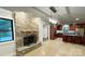 Open-concept room with hardwood floors, stone fireplace, modern light fixtures and view of updated kitchen at 209 Falcon Dr, Concord, NC 28025