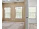 Bright bedroom with natural light, featuring two windows and a glimpse into the walk-in closet at 212 Township Dr, Fort Mill, SC 29715