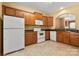 Functional kitchen with wooden cabinets, white appliances, and view into the dining room at 212 Township Dr, Fort Mill, SC 29715