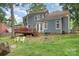 A charming backyard featuring a wooden deck, grassy area, and natural landscaping, creating a serene outdoor space at 2133 Highland View Ln, Charlotte, NC 28214