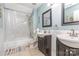 Bright bathroom featuring double sinks, tile floors, and a shower with marble-style tile surround at 2133 Highland View Ln, Charlotte, NC 28214