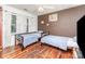 room featuring two twin beds, hardwood floors, a ceiling fan, and brown accent wall at 2133 Highland View Ln, Charlotte, NC 28214