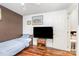 Cozy bedroom featuring hardwood floors, a ceiling fan, art, and a television at 2133 Highland View Ln, Charlotte, NC 28214