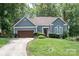 Charming home featuring blue siding, a well-manicured lawn, and an attached two-car garage at 2133 Highland View Ln, Charlotte, NC 28214
